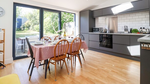 Una cocina moderna con comedor, ventanas amplias y vistas al exterior.