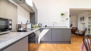 Una cocina moderna con horno integrado, hervidor y lavabo.