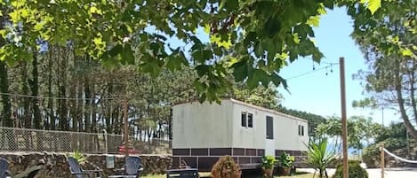 A recreational area with a trailer, outdoor furniture, and a hammock.