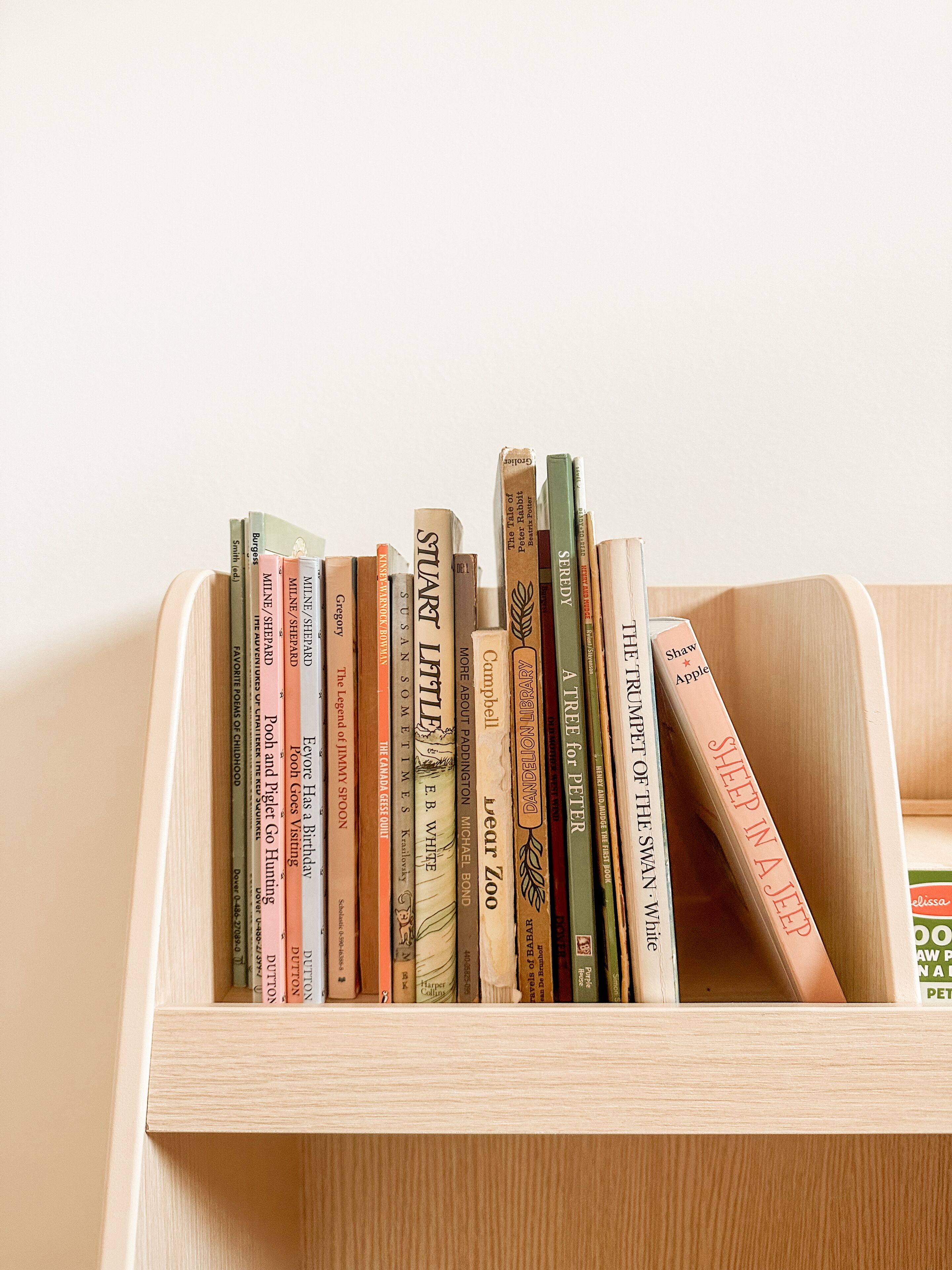A wooden bookcase filled with various books.