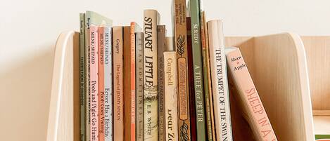 A wooden bookcase filled with various books.