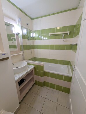 Une salle de bain avec un lavabo, un miroir et une baignoire.