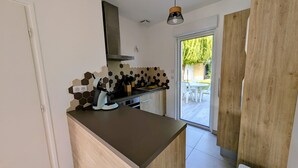A modern kitchen with a wooden countertop, a built-in stove, and a hexagonal backsplash.