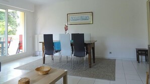 A dining area with a table, chairs, and a hanging light fixture. - Spacious cocoon with two terraces (Montpellier)