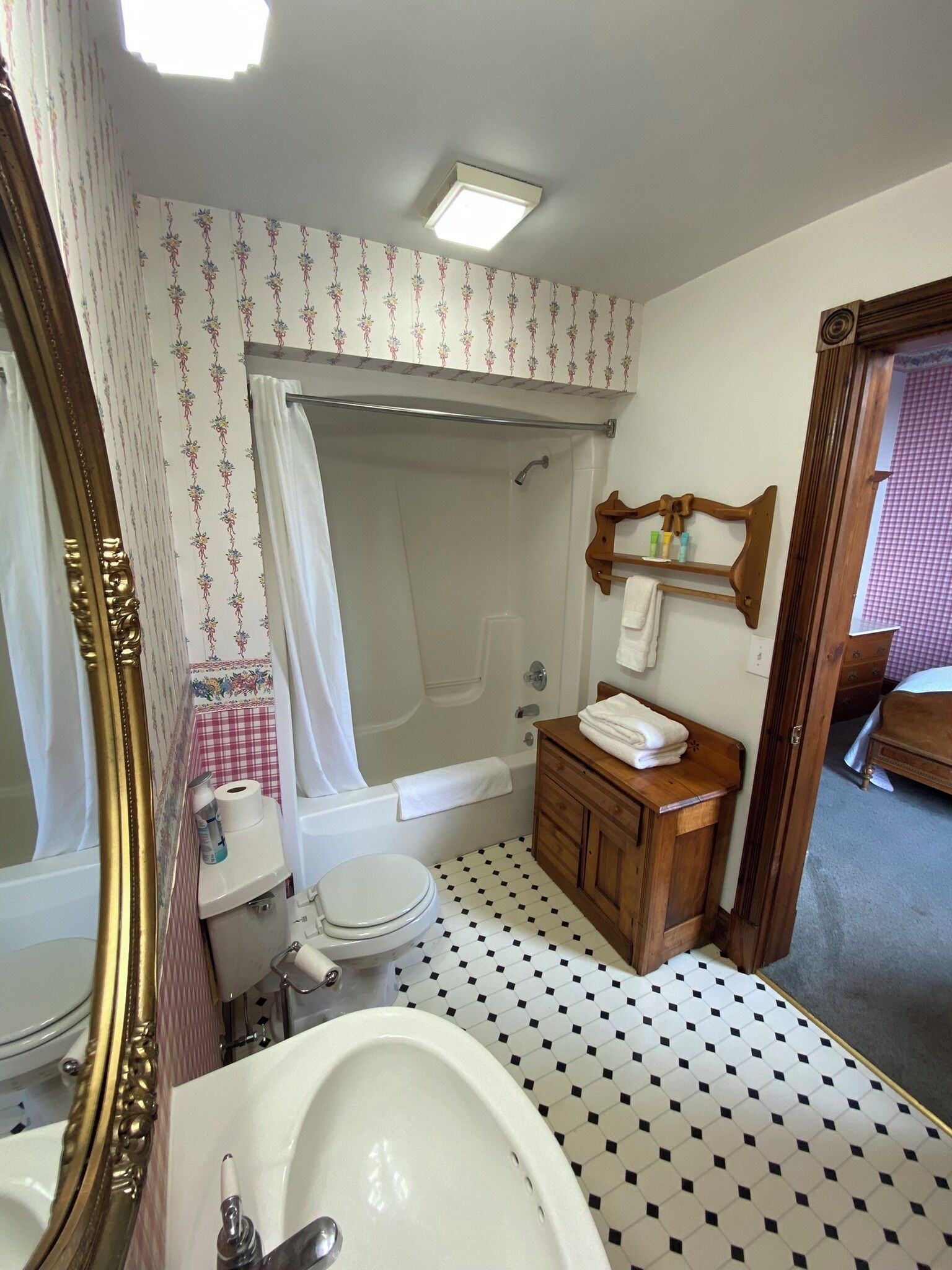 Un baño con bañera, inodoro, lavamanos y tocador.