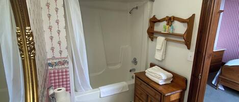 Un baño con bañera, inodoro, lavamanos y tocador.