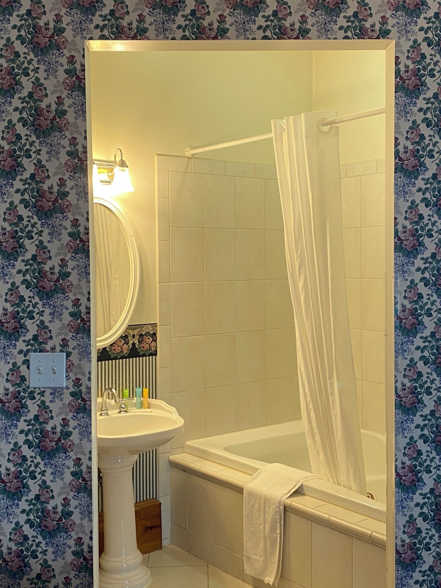 A bathroom with a bathtub, a sink, and a mirror.