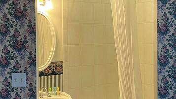 A bathroom with a bathtub, a sink, and a mirror.