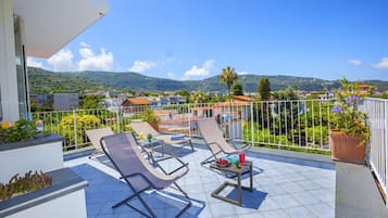 Enjoy breathtaking views of the surrounding mountains from this balcony, complete with comfortable lounge seating and a convenient table for snacks and drinks.