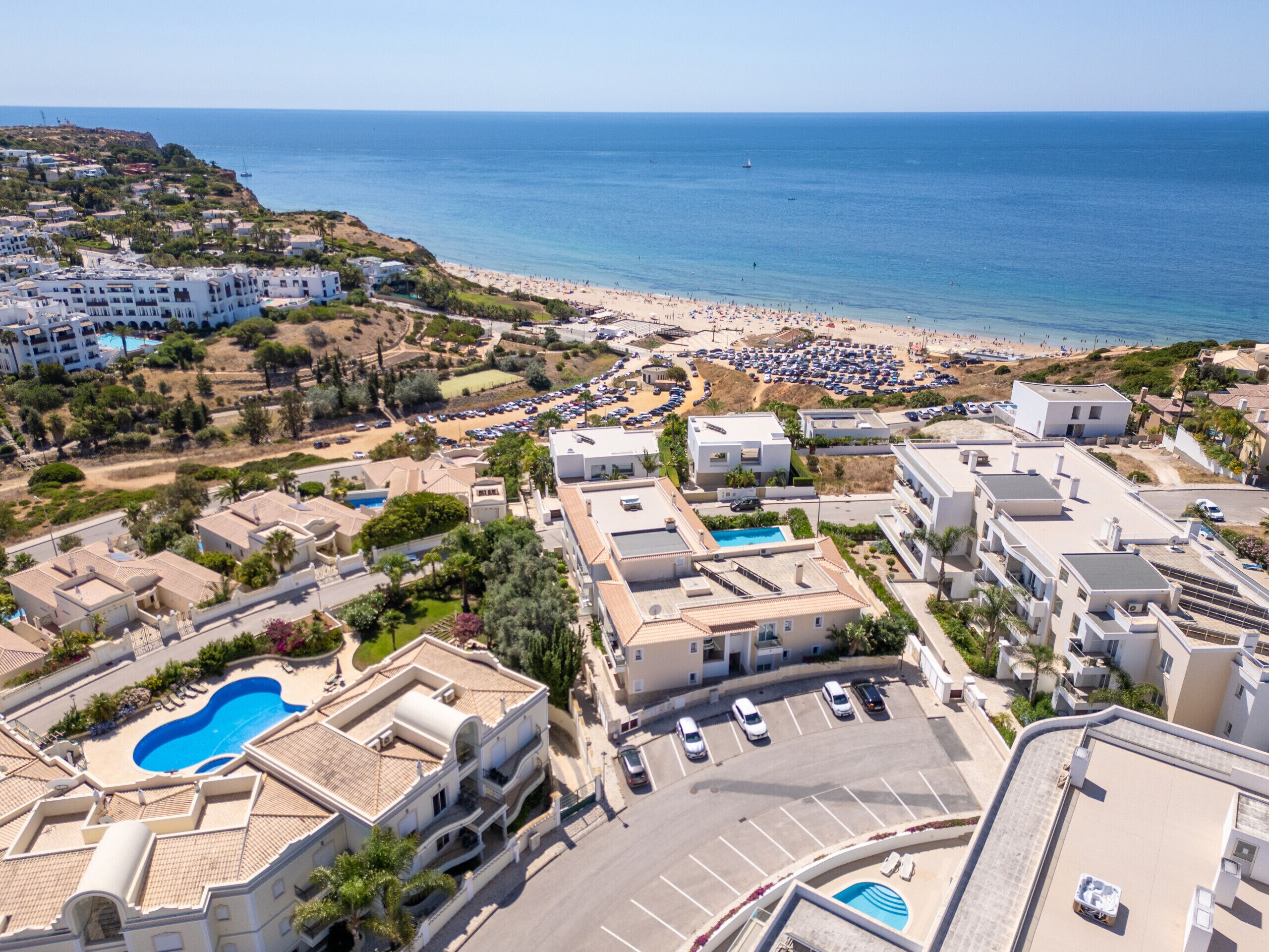 A coastal resort with a large pool, beach access, and a view of the sea.