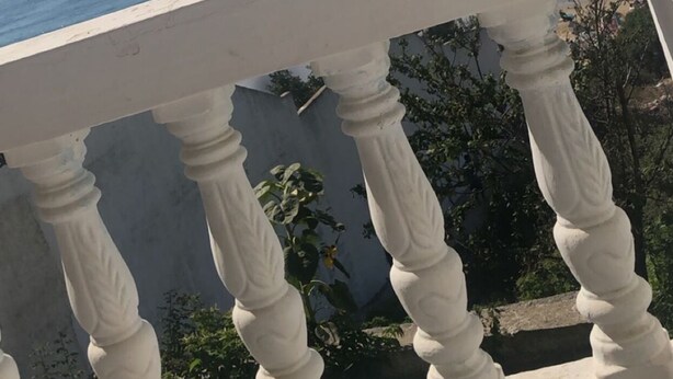 A balcony with white balustrades overlooking a clear blue sea. - Inviting 1-bed Apartment in Ksar Sghir (Ksar El Majaz)