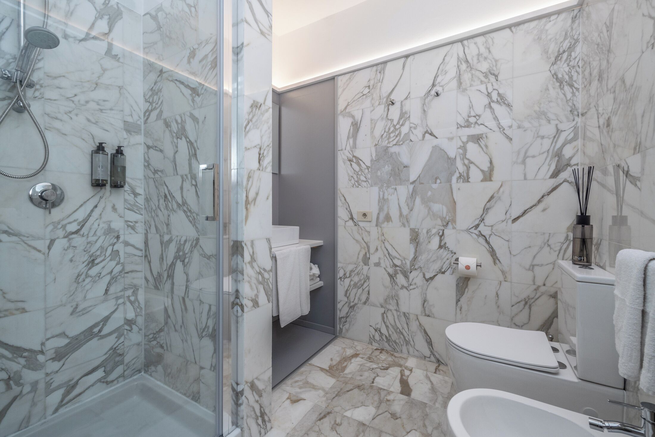 Une salle de bain moderne avec une douche à parois de verre, des toilettes et une baignoire.