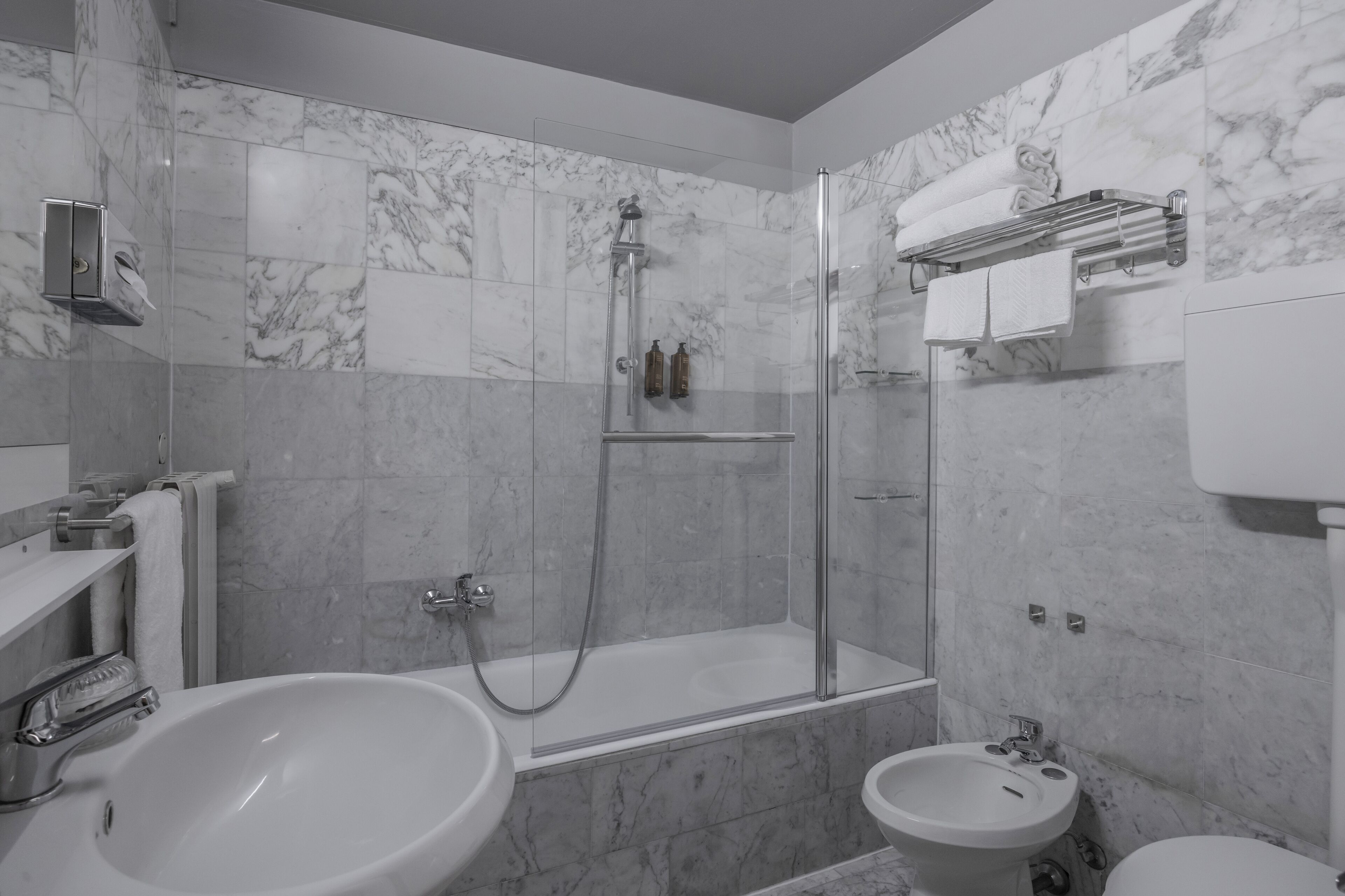 A modern bathroom with a bathtub, a shower, and two sinks.