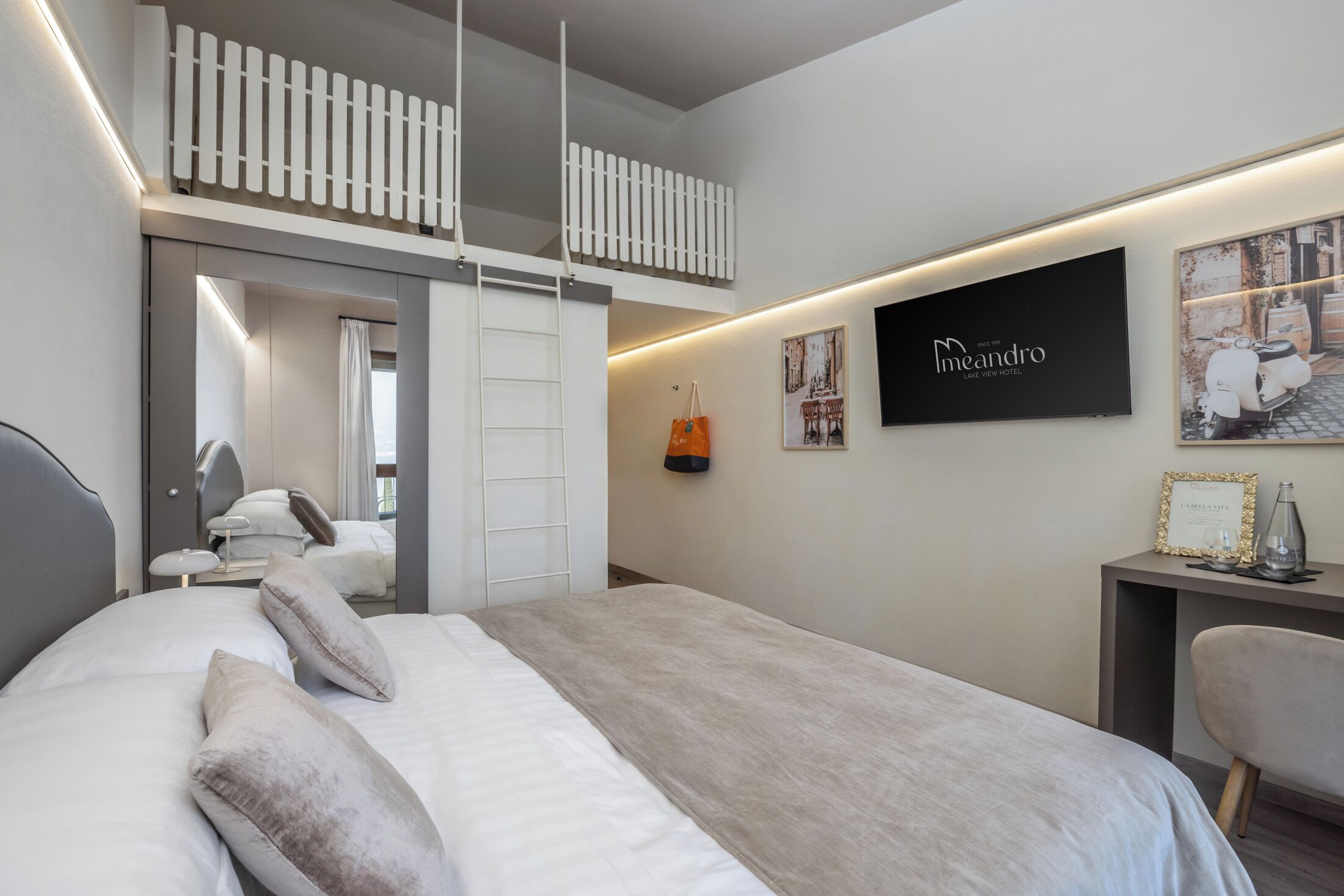 Una habitación de hotel moderna con cama, escritorio y un pequeño balcón.