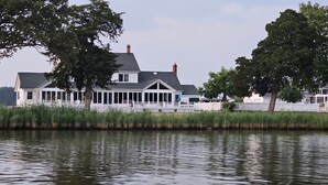 A waterfront house with a covered porch and a dock.