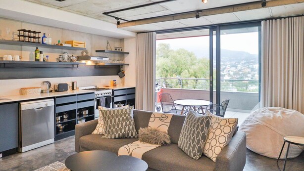 Een moderne keuken met inbouwapparatuur en een eethoek met uitzicht op de stad.