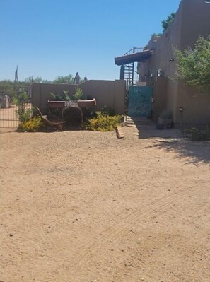 Guests can enjoy a tranquil outdoor space with a garden bed and a metal gate.