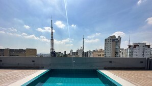 Una piscina en la azotea con vistas despejadas al horizonte urbano.