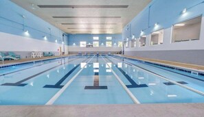 A large indoor swimming pool with clear lanes, a tiled floor, and a ceiling with recessed lighting. - #2400 Pointe - Studio Suite at Mariners SML (Huddleston)