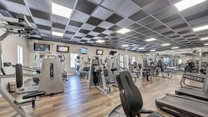 Et fitnesscenter med forskellig træningsudstyr, herunder løbebånd og styrkemaskiner.
