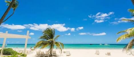 Ranta lähistöllä, aurinkotuoleja, rantapyyhkeitä