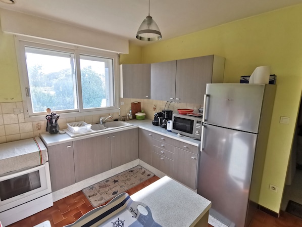 A compact kitchen with a microwave, refrigerator, and sink.