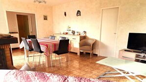 A dining area with a table and chairs, a television, and a sofa. - La Maison du Verger - 13km from the beach (Sainte-Foy)
