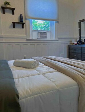 Cozy retreat with a neatly made bed and a window offering a view.