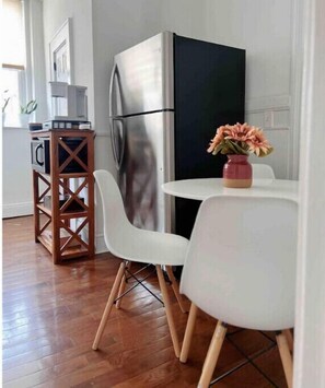 Modern kitchen area with a refrigerator, sideboard, and dining table.