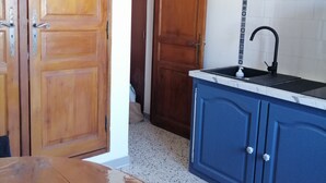 A kitchen with wooden cabinets, a sink, and a tiled backsplash.