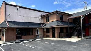 A parking lot with a building that has a brick facade and a flat roof.