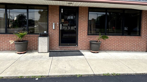 A brick building with a black door and large windows.