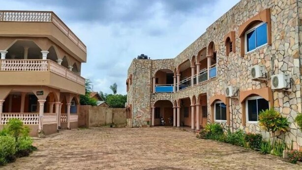 Un patio con un edificio de piedra, balcones y ventanas arqueadas.