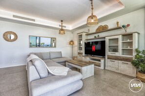 A modern living room with a sectional sofa, wooden coffee table, and a flat-screen TV. - Mila | Sea views - pool - gym (Torremolinos)