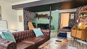 Un salon avec un canapé en cuir marron, une table basse en bois et une cheminée.