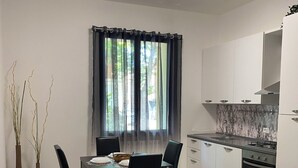 A compact kitchen with white cabinets, a gas stove, and a tiled backsplash.