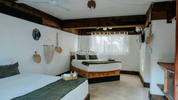 Habitación cuádruple Deluxe | Ropa de cama de alta calidad y minibar