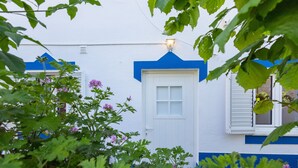Un edifici blanc amb adorns blaus i una porta amb finestral.