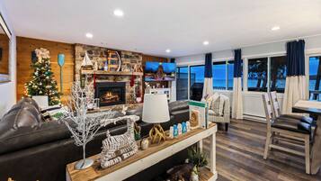 A wall of windows on the bay, with the fireplace and tree glowing through the holidays.