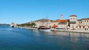 Une ville côtière dotée de bâtiments historiques, d’une promenade en bord de mer et d’un clocher d’église imposant.