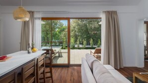 Una sala de estar moderna con un sofá, una mesa de comedor con sillas y una zona de cocina.