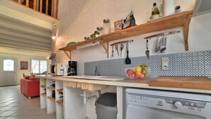 Eine Küche mit Holzböden, einer Waschmaschine und einer gefliesten Spritzschutzwand.