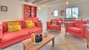 Ein Wohnzimmer mit einem roten Sofagarnitur, einem Holztisch und einem roten Schrank.