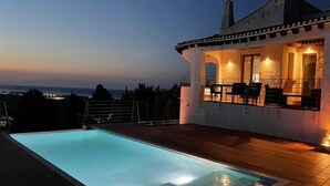 Une piscine avec vue sur la mer au crépuscule.