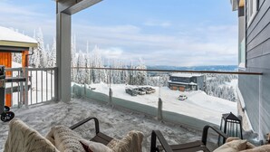 Un balcon donnant sur un paysage enneigé et une station de ski.