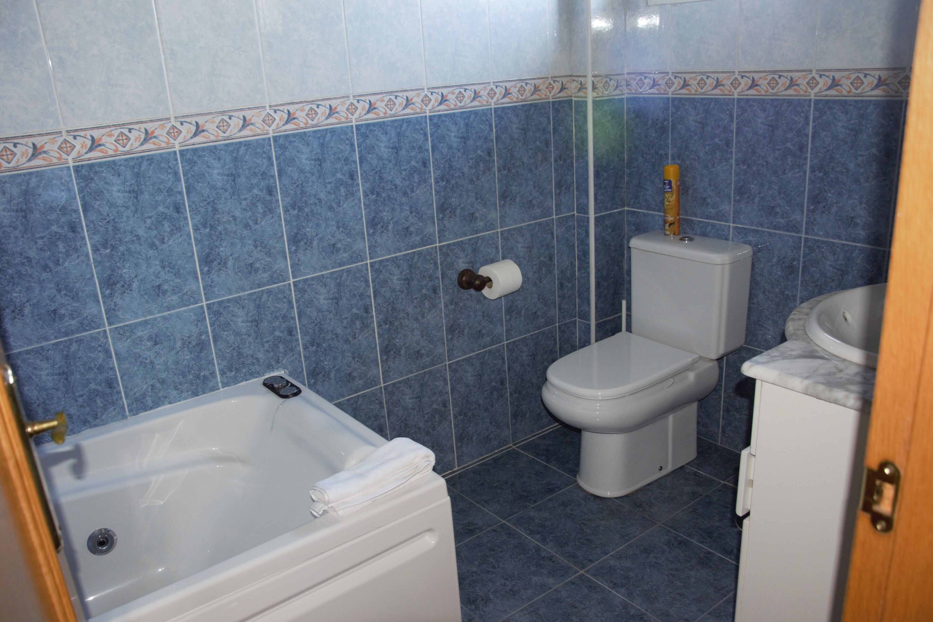 A bathroom with a bathtub, toilet, and sink.