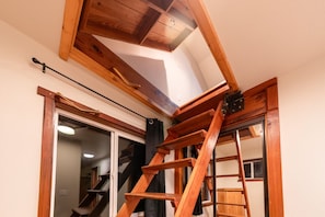 A wooden staircase leading to a lofted area with a skylight. - Tranquil Pond Views, Relax in Nature (Brookings)