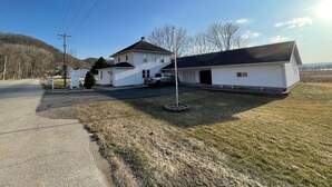 Ein zweigeschossiges Haus mit Garage, Auffahrt und klein eingezäunter Garten.
