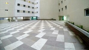 A spacious indoor area with a checkered floor pattern, large windows, and a high ceiling. - Terraços do Atlântico By Solemar (Fortaleza)
