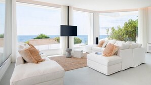 A modern living room with a large window overlooking a scenic view. - Villa Iolande - Seafront villa with pool in Sicily (Fontane Bianche)